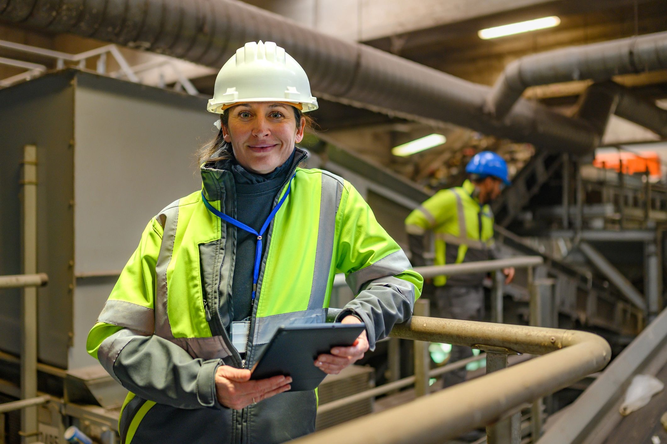 Engineer performing quality inspection with tablet in an industrial environment