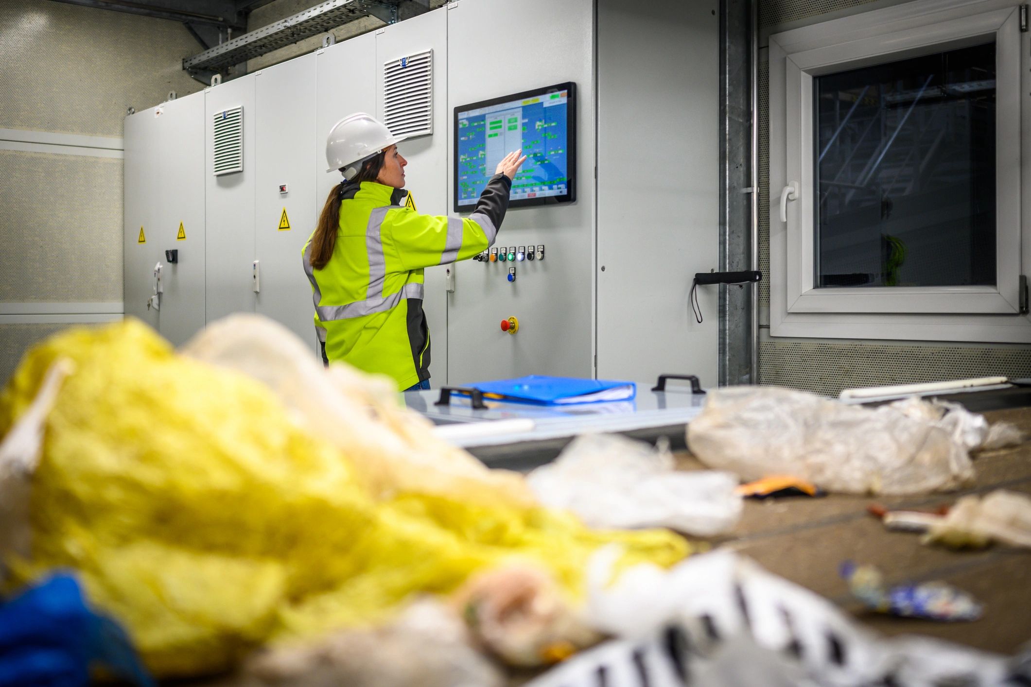 Industrial operator at control panel representing monitoring and operations